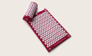 Pink bed of nails mat and pillow. 